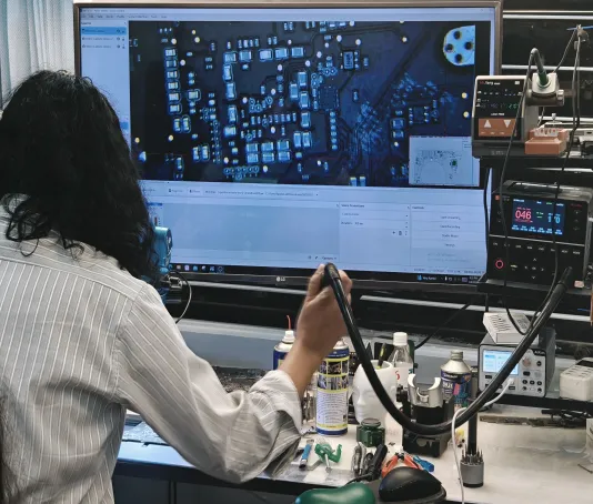 Technician repairing a laptop logic board